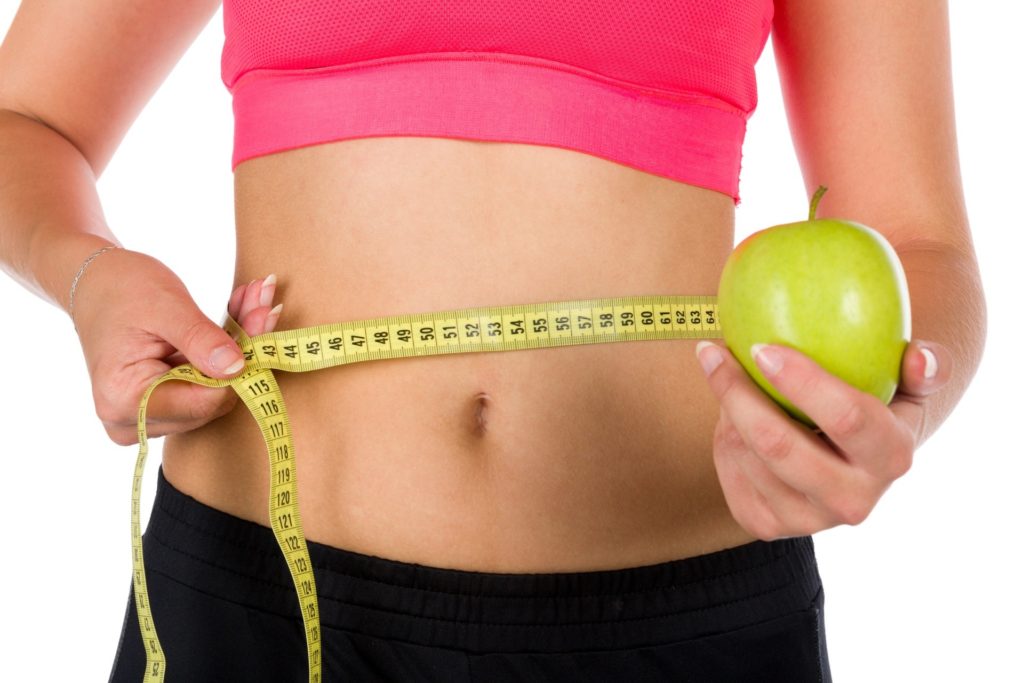 woman holding apple and ribbon tape measure lose weight